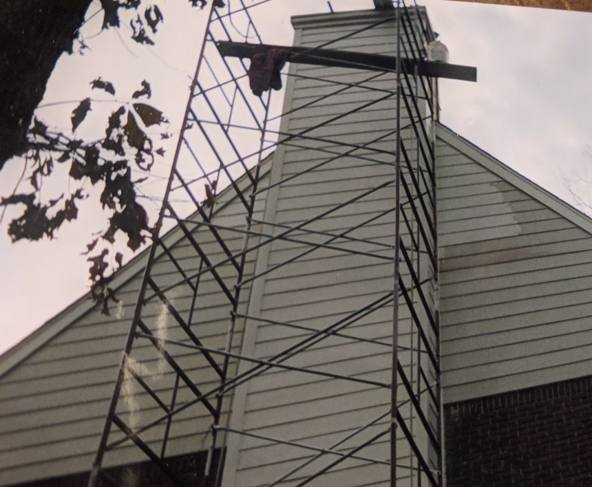 scaffolding alongside the two-story chimney of a house