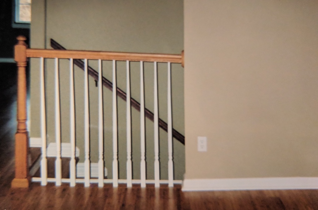 a decorative wooden railing for an interior basement staircase