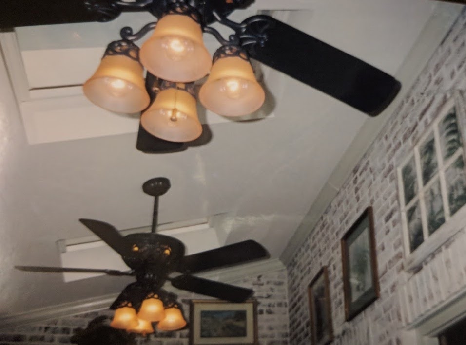 a newly- installed pair of ceiling fans with decorative light sconces 