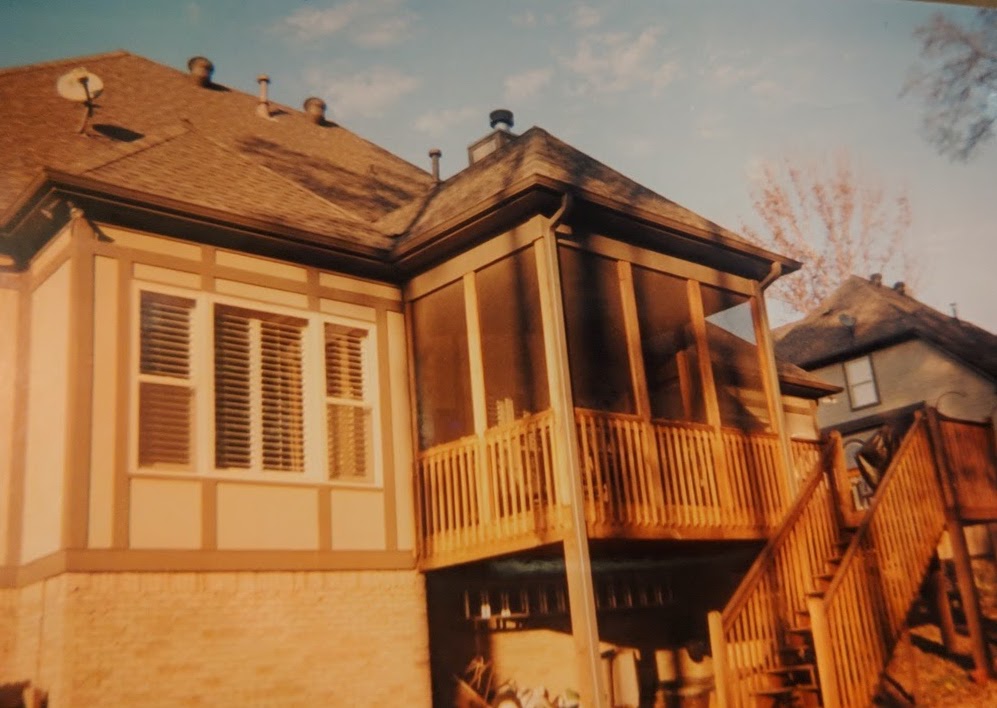 a renovated second-story outdoor enclosed porch on wooden beams