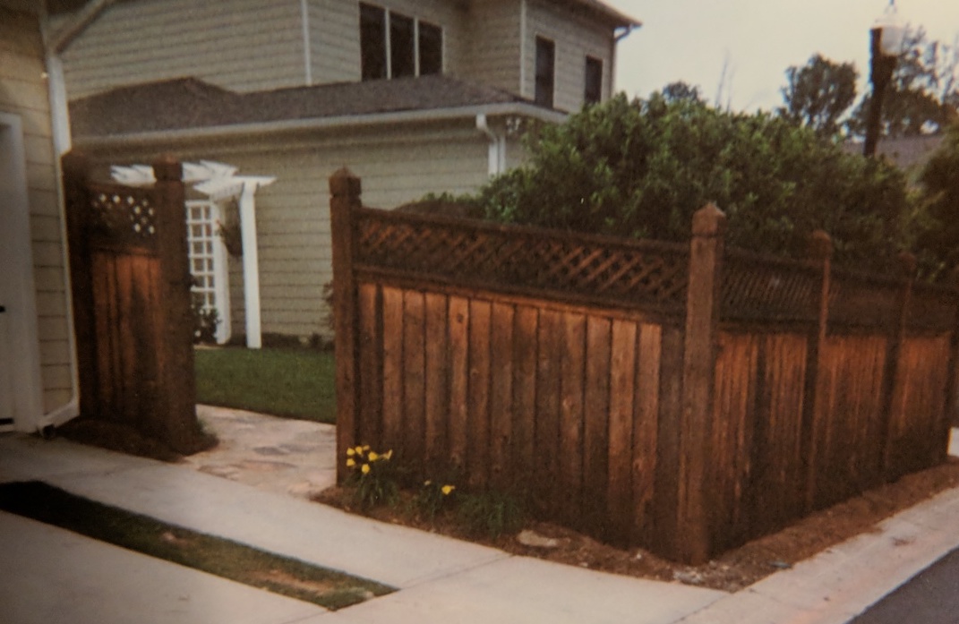 a front yard wooden fence topped in its full length by a decorative trellis