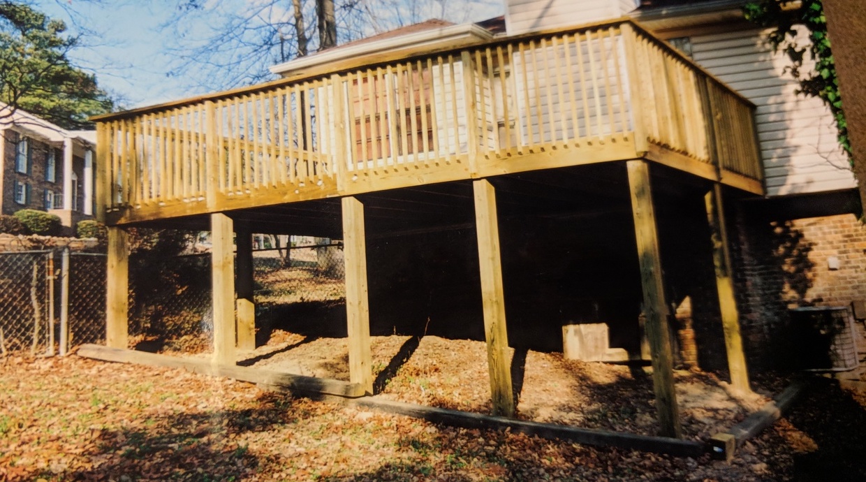 horizontal view of second-story deck along back of house held up by beams around the deck's perimeter