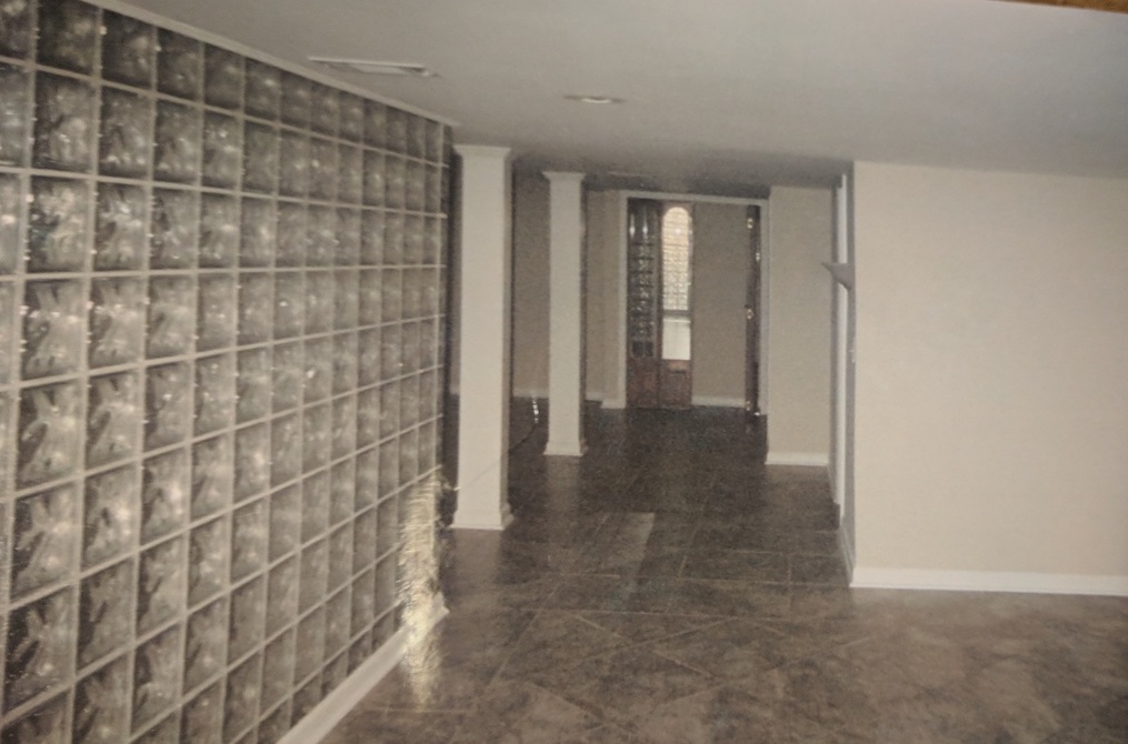 wide view of room with tall white pillars and glass tile walls