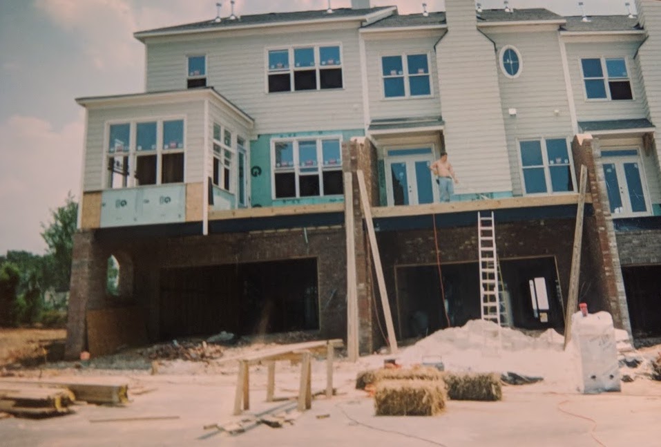 two wide garages behind a large house under construction